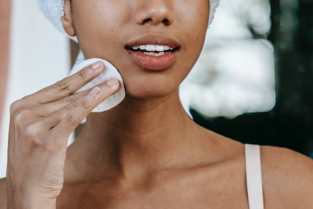 women applying rose water on her face