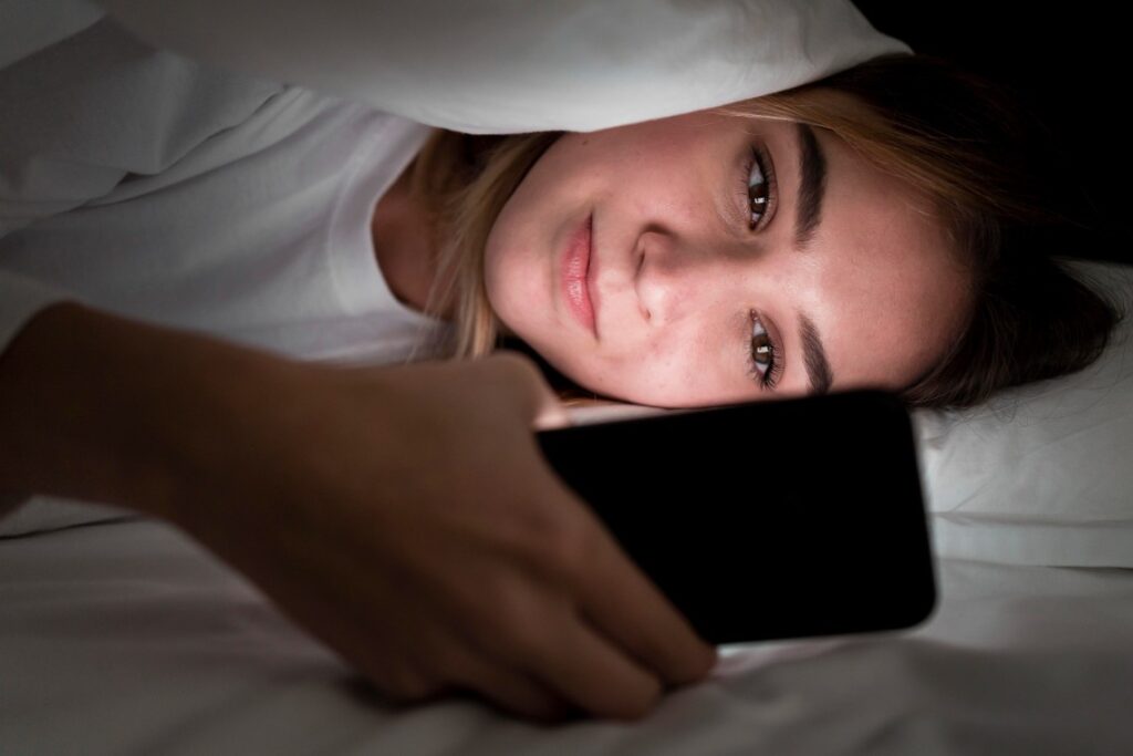 Girl using mobile phone at the time of sleep